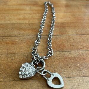 Neck chain has heart with crystals and heart lock plain with toggle clasp.